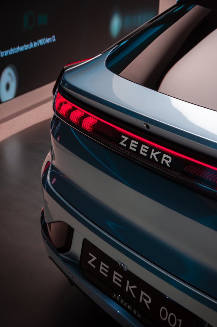 Rear view of a modern Zeekr car with illuminated taillights in a sleek showroom.